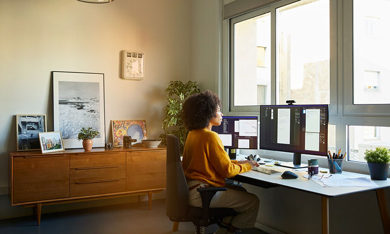 Woman in yellow jumper working at a computer