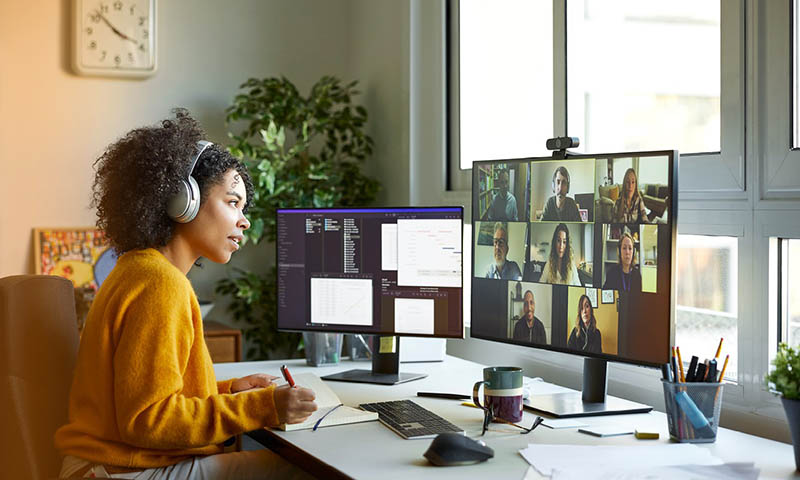 Woman wearing yellow having a zoom meeting on the computer