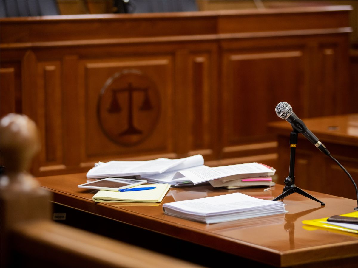 Table in a courtroom with papers and microphone