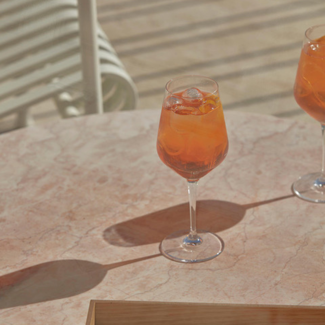 Photo of orange cocktail on stone outdoor table
