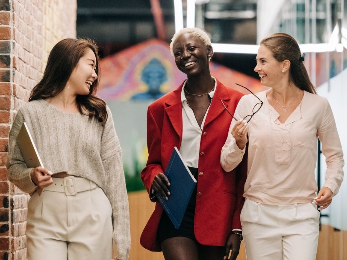Group of three women in professional clothing walking together